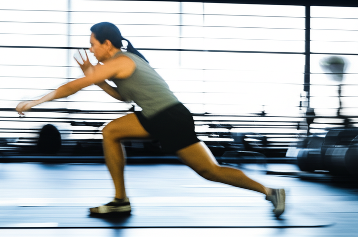 Person performing efficient, high-intensity exercises in a gym to save time.